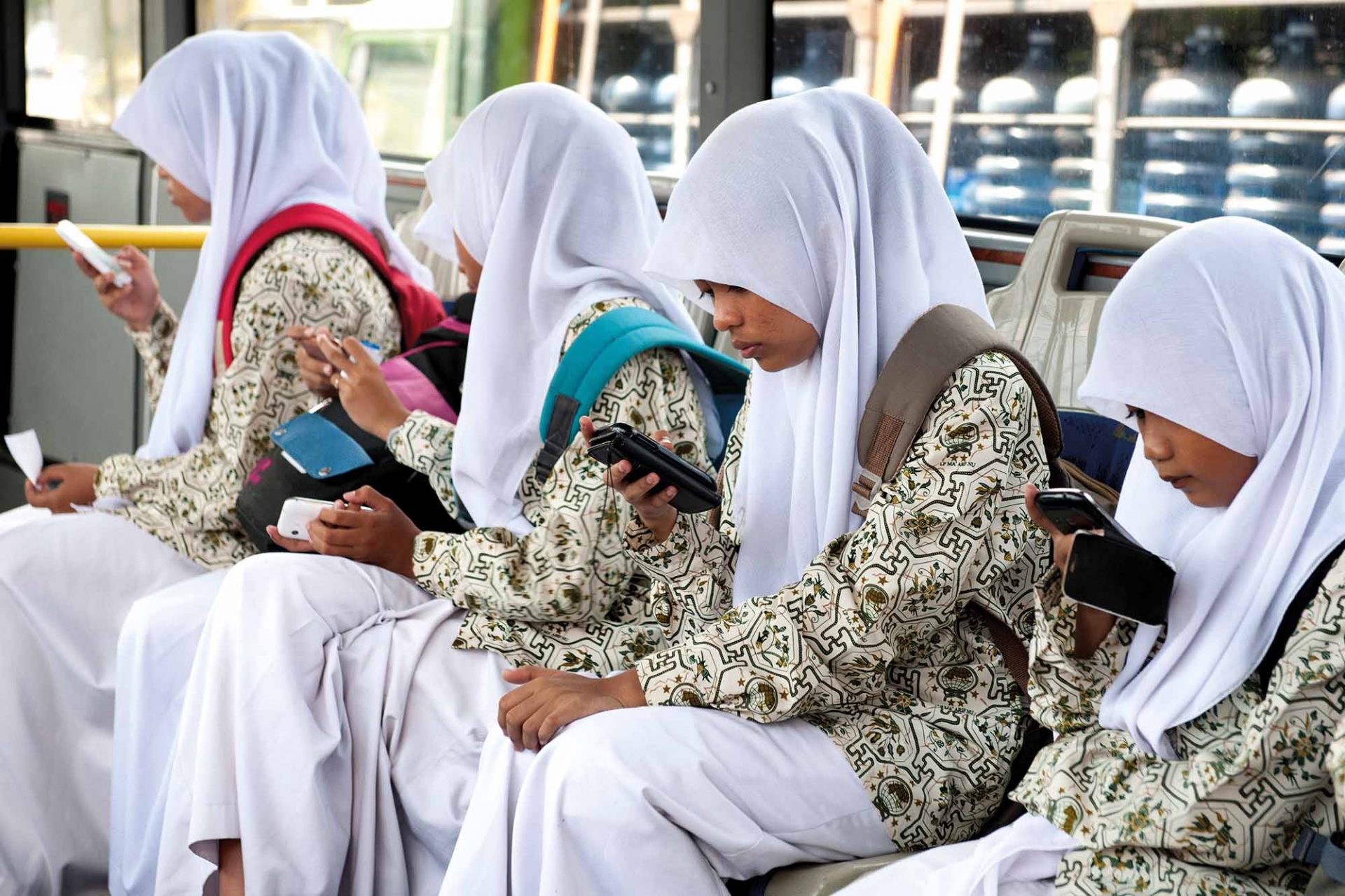 Balinese School Girls With Their Smart Phones On A Bus In Bali, Indonesia.. Image Shot 10/2014. Exact Date Unknown.