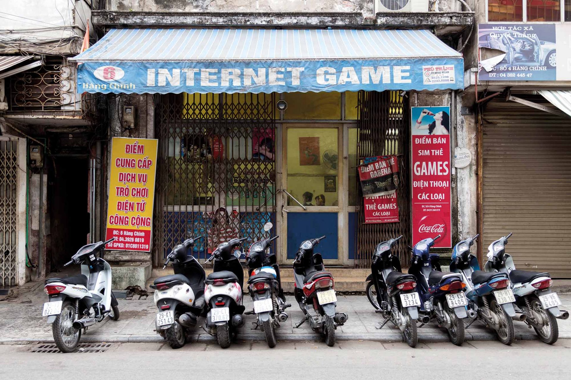 Exterior Of An Internet Cafe In Hanoi Vietnam, Early In The Morning. People Inside Must Have Been There All Night.